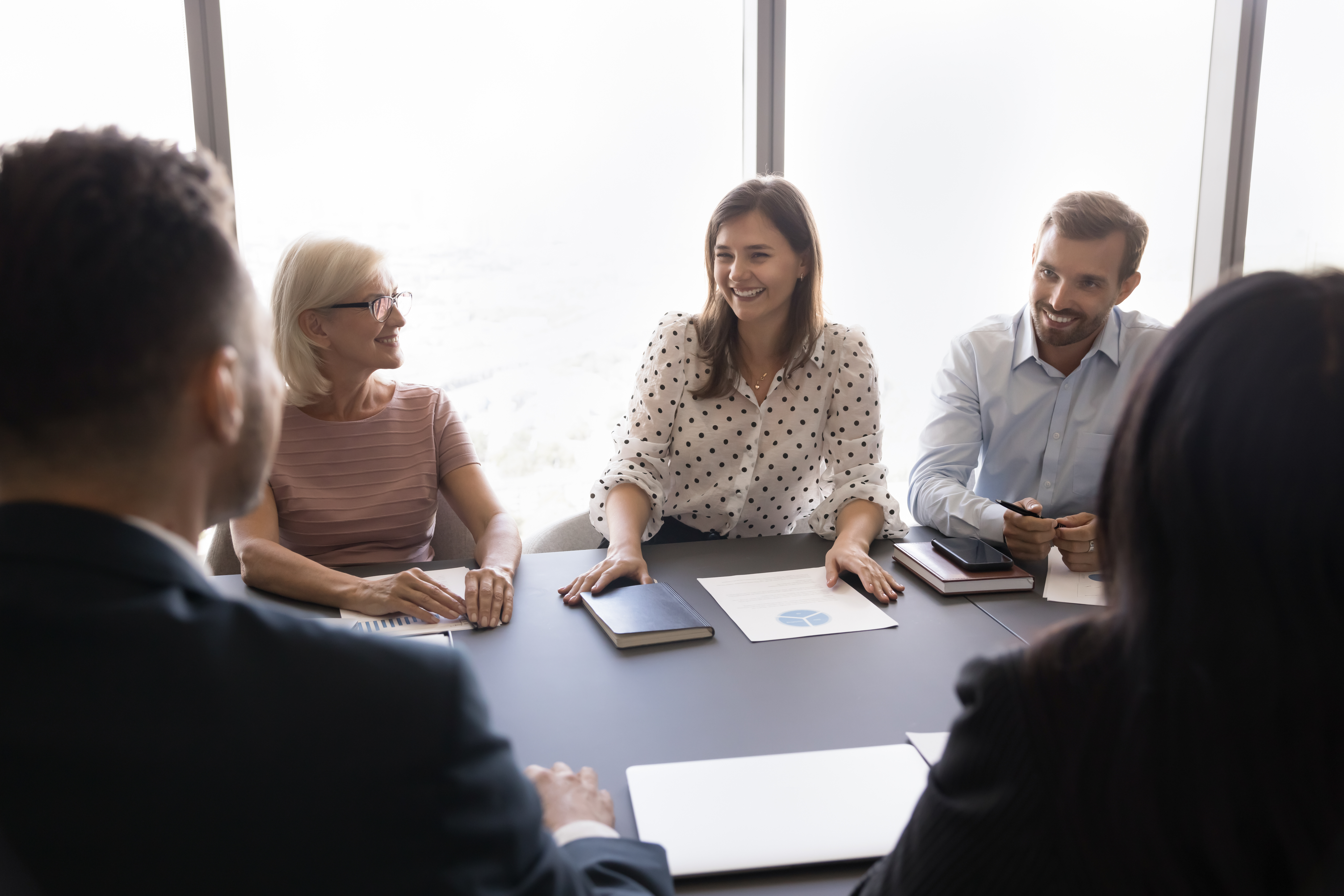 Young and mature teammates listening millennial female meeting participant