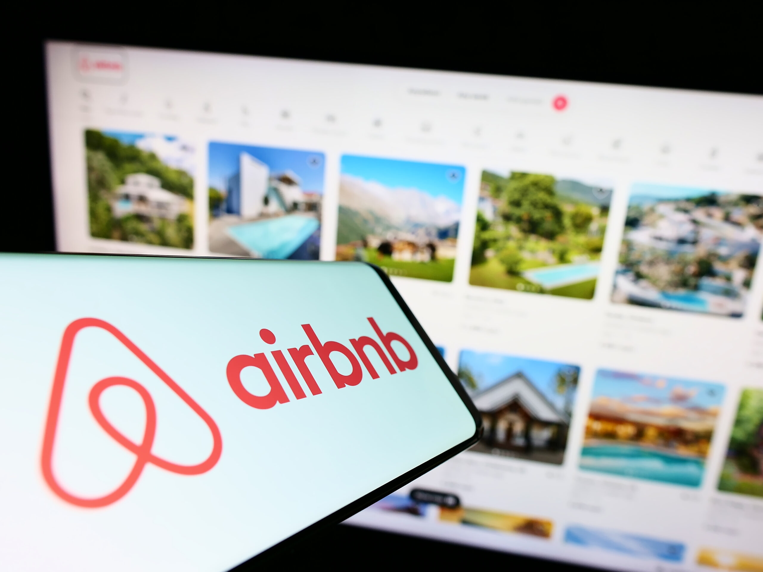 Stuttgart, Germany - 11-30-2022: Smartphone with logo of American homestay marketplace company Airbnb Inc. on screen in front of business website. Focus on right of phone display